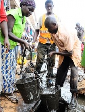 Cleaning. Residents scoop sewage from a